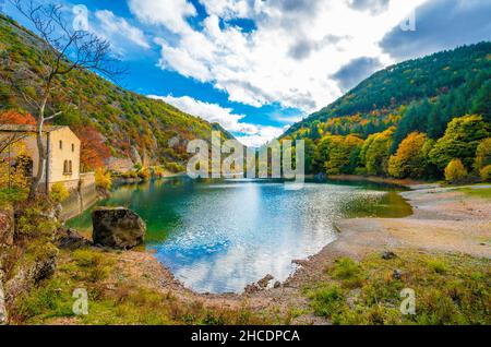 Villalago (Abruzzen, Italien) - Ein Blick auf das mittelalterliche Dorf in der Provinz L'Aquila, in den Schluchten des Schützen, mit Lago San Domenico See, am Laub Stockfoto