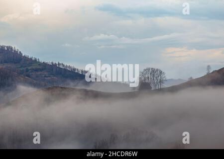 Traditionelle reetgedeckte Hütte, die im Nebel vor einem malerischen Himmel liegt. Foto aufgenommen am 30th. April 2021 im alten Dorf Dumesti, Kreis Alba, Roma Stockfoto