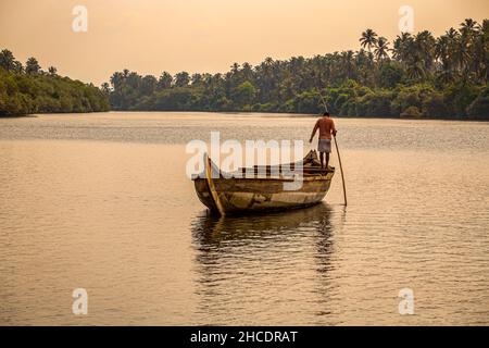 Einsamer Bootsmann, der auf den Kerala Backwaters Kanälen navigiert. Foto aufgenommen am 30th. April 2018 auf dem Kannur Backwaters, Kerala, Indien. Stockfoto