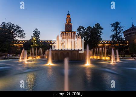 Wasserbrunnen vor dem Castello Sforza (Castello Sforzesco) während der blauen Stunde des Sonnenuntergangs. Foto aufgenommen am 19th. August 2021 in Mila Stockfoto