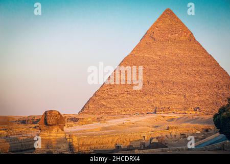 Die große Pyramide von Gizeh und die Sphinx, die zur goldenen Stunde des Sonnenaufgangs gesehen wird. Foto aufgenommen am 21st. Juni 2021, auf dem Gizeh Plateau, Kairo, Ägypten. Stockfoto