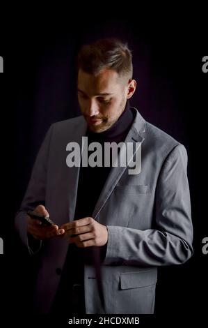Porträt eines jungen Geschäftsmannes, der eine Nachricht auf seinem Smartphone liest Stockfoto