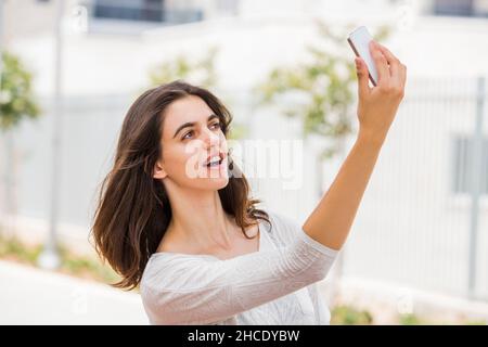 Junge Frau in legerer Sportkleidung nimmt ein Selfie draußen Stockfoto