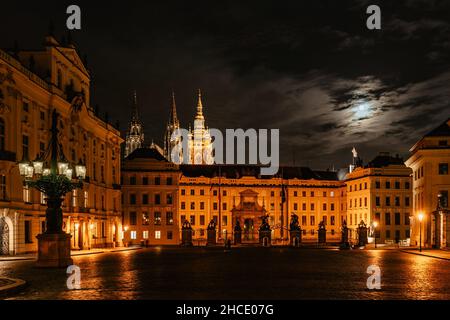Haupttor der Prager Burg mit Statuen bei Nacht, beleuchtete St. Veits Kathedrale im Hintergrund.UNESCO-Website, berühmtes Reiseziel.Abendstadt Stockfoto