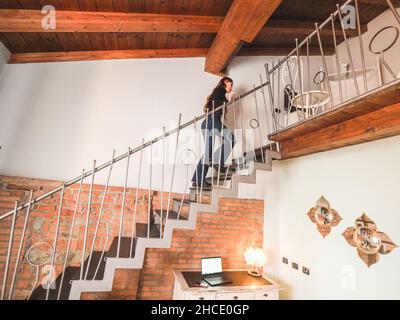 Junge schöne stilvolle kaukasische weibliche Klettern die Treppe in ihrem Haus Stockfoto