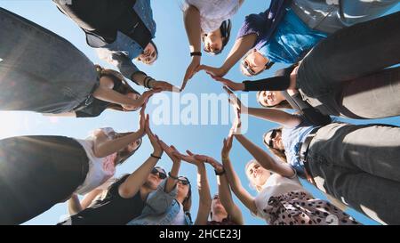 Fröhliche Freundinnen bilden aus ihren Händen eine Herzform. Stockfoto