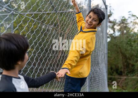 Glückliche Kinder, die mit Händen spielen. Freundschaftskonzept mit südasiatischen Kindern, die zusammen spielen. Stockfoto