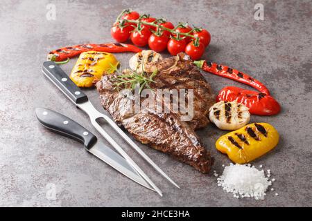 Köstliches Steakhouse Porterhouse Steak und buntes frisches Braten Gemüse auf grauem Hintergrund aus nächster Nähe. Horizontal Stockfoto