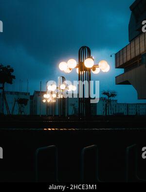 Vertikale Aufnahme der Straßenlaternen am Abend. Stockfoto