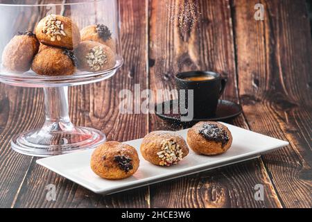 Bombolon oder Bomboloni ist ein italienisches gefülltes Donut- und Snackfutter. Deutsche Krapfen - Krapfen oder berliner - gefüllt mit Marmelade und Schokolade Stockfoto