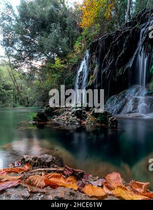 Malerischer Blick auf den Wasserfall, der durch felsige Formationen in üppig grünen Wäldern in Katalonien in Spanien fließt Stockfoto