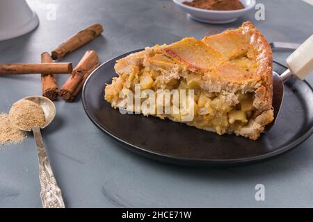 Ein Stück köstlichen hausgemachten Zucchini-Kuchen serviert auf dem Teller auf dem Tisch in der Nähe von Zimtstangen Stockfoto