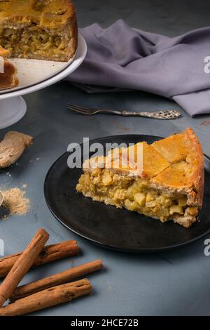 Ein Stück köstlichen hausgemachten Zucchini-Kuchen serviert auf dem Teller auf dem Tisch in der Nähe von Zimtstangen Stockfoto