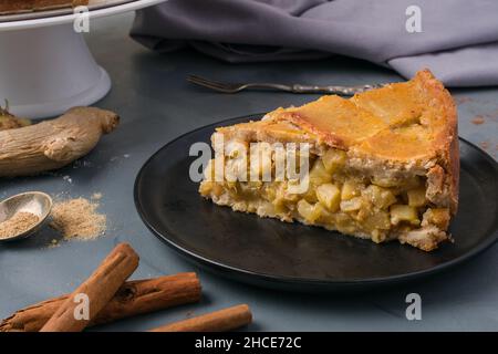 Ein Stück köstlichen hausgemachten Zucchini-Kuchen serviert auf dem Teller auf dem Tisch in der Nähe von Zimtstangen Stockfoto