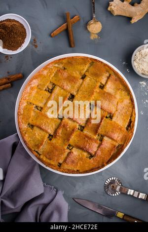 Blick von oben auf leckere hausgemachte gebackene Zucchini Kuchen Platz auf dem Tisch in der Nähe von gemahlenem Zimt und Sticks und Geschirr Stockfoto