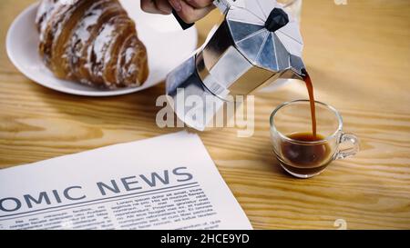 Beschnittene Ansicht des Mannes, der Kaffee aus der Mokakanne gießt, Stockbild Stockfoto