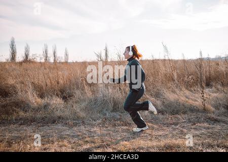 Sportliche junge Frau läuft im Park und hört Musik. Sport Stockfoto