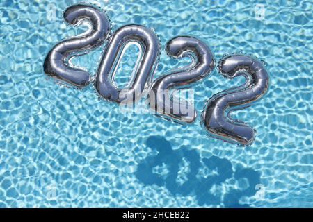 2022 glücklicher Text für das neue Jahr. Zahlen zum neuen Jahr auf blau Stockfoto