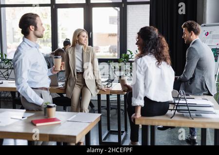 Junge, multiethnische Kollegen aus der Wirtschaft, die Kaffee trinken, um im Büro zu sprechen Stockfoto