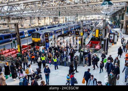 Pendler, die mit Zügen und in belebten Bahnhöfen unterwegs sind Stockfoto