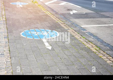 Leerer Fahrradweg aus Stein, der entlang von Parkplätzen entlang einer Straße im Stadtzentrum verläuft Stockfoto