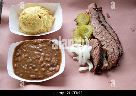 Nahaufnahme einer Papierschüssel mit roter Bohnensuppe mit Scheiben gebratenem Rindfleisch mit Gemüse Stockfoto