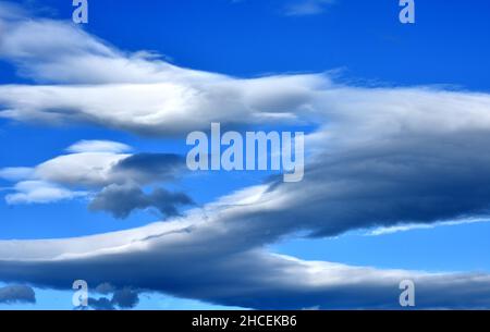 Ltocumulus lenticularis Wolken, besser bekannt als Lentikularwolken. Diese stationären, lentikulären oder „UFO“-Wolken, die glatt und übereinander erscheinen Stockfoto