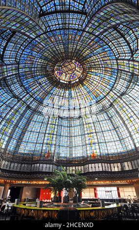 Die Brasserie Printemps, ein Restaurant im Flaggschiff-Kaufhaus Printemps am Boulevard Haussmann in Paris, ist mit einer verzierten Buntglaskuppel überspannt. Stockfoto