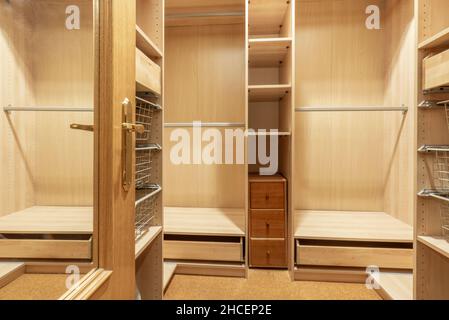 Garderobe mit Holzeinteilungen und Kleiderstangen zum Aufhängen von Kleidung Stockfoto