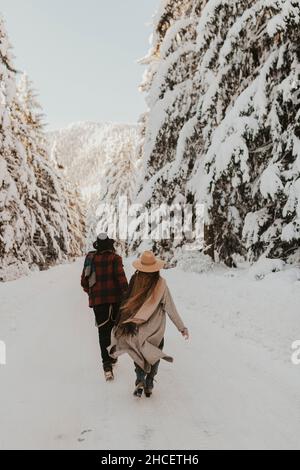 Eine schöne Aussicht auf ein Paar, das im Winter im Wald spazierengeht Stockfoto