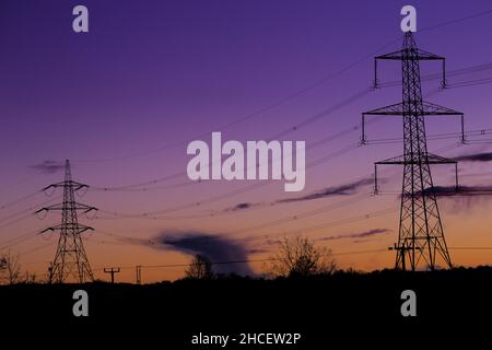 Blaue Stunden-Aufnahme von Pylonen, die gegen den frühen Nachthimmel in der Nähe von Eckington, North East Derbyshire, gedreht wurden Stockfoto