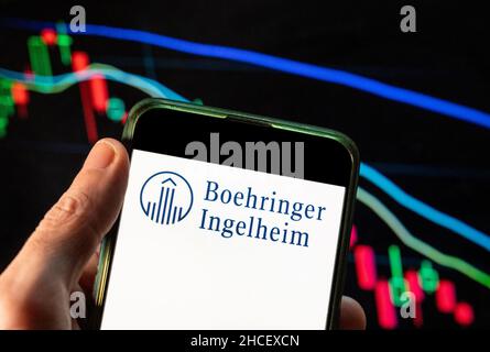 China. 09th Dez 2021. In dieser Fotolabbildung ist das Logo des forschungsgetriebenen deutschen Pharmaunternehmens Boehringer Ingelheim auf einem Smartphone mit einem wirtschaftlichen Börsenindex im Hintergrund zu sehen. (Foto von Budrul Chukrut/SOPA Images/Sipa USA) Quelle: SIPA USA/Alamy Live News Stockfoto