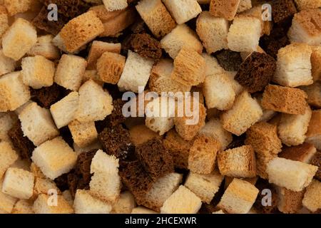 Stapel hausgemachter Brotcroutons, Hintergrund hausgemachter rus, Draufsicht, knusprige Brotwürfel, trockener Roggen- und Weizenkrümel, Crouoton oder gerösteter Cracker-Würfel Stockfoto