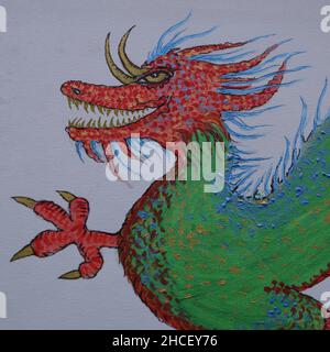 Kopf eines grünen chinesischen Drachen mit rot und blau. Seine Augen, Zähne und Krallen sind golden. Stockfoto