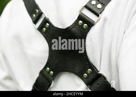 Ausladen des Kameratriemens auf der Frau in der weißen Jacke aus nächster Nähe. Stockfoto