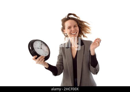 Lächelnde Frau, die eine große Uhr in den Händen hält. Zeit zum Ausruhen, Entspannen, Urlaubskonzept. Isoliert auf Weiß Stockfoto