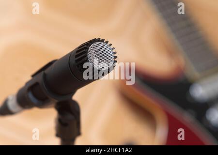 Dynamisches Mikrofon mit einer E-Gitarre im Hintergrund Stockfoto