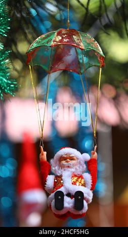 Niedlicher Kleiner Weihnachtsmann, Der Am Baum Aufgehängt Wird Stockfoto