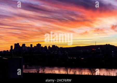 Ein dramatischer Sonnenuntergang über der Silhouette der Skyline von Montreal in Quebec, Kanada Stockfoto