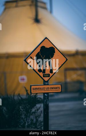 Vertikale Aufnahme eines Schildes in französischer Sprache „WATCH FOR CHILDREN“ mit einer Elefantensilhouette Stockfoto