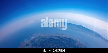 Die Verbodung des Planeten Erde. Luftaufnahme. Blauer Himmel und Wolken über der Insel im Meer. Raum, Wissenschaftskonzept Stockfoto