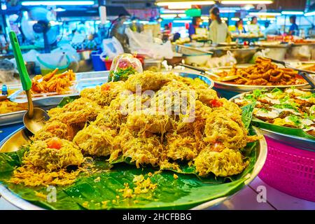 Die Schüssel mit frittierten Fischstücken im Ei auf den grünen Bananenblättern, Tanin Market, Chiang Mai, Thailand Stockfoto