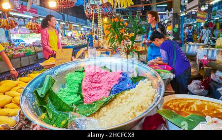 CHIANG MAI, THAILAND - 4. MAI 2019: Der Stand des Farmers Gate Market verkauft Zutaten für klebrigen Mangoreis Thai-Dessert - farbigen Reis, frische Mangos Stockfoto