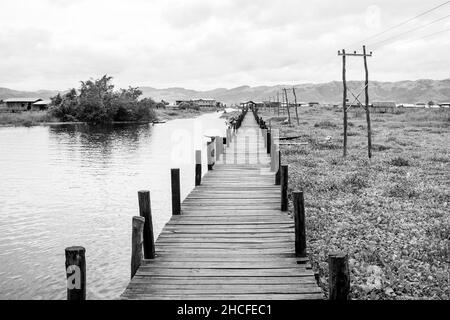 Eine hölzerne Brücke wurde verwendet, um entlang der Städte von Inle Lake, Shan Region, Myanmar, als der Wasserstand steigt Stockfoto