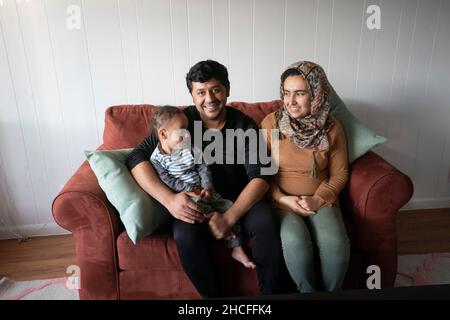 Austin, TX, USA. 19th. November 2021. Eine afghanische Familie posiert in ihrer neuen Wohnung in der Nähe der University of Texas in Austin. Drei Monate lang werden Flüchtlinge, die vor den Unruhen in Afghanistan fliehen, nach Texas umgesiedelt, wobei viele alleinstehende Männer, große Familien mit Kindern, unter Dutzenden von Wohnungen in Austin, Texas, settelten. Religiöse Gruppen haben sich verstärkt, um die Bemühungen um die Einrichtung von Häusern für Hunderte von Flüchtlingen zu koordinieren. (Bild: © Bob Daemmrich/ZUMA Press Wire) Stockfoto