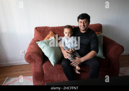 Austin, TX, USA. 19th. November 2021. Eine afghanische Familie posiert in ihrer neuen Wohnung in der Nähe der University of Texas in Austin. Drei Monate lang werden Flüchtlinge, die vor den Unruhen in Afghanistan fliehen, nach Texas umgesiedelt, wobei viele alleinstehende Männer, große Familien mit Kindern, unter Dutzenden von Wohnungen in Austin, Texas, settelten. Religiöse Gruppen haben sich verstärkt, um die Bemühungen um die Einrichtung von Häusern für Hunderte von Flüchtlingen zu koordinieren. (Bild: © Bob Daemmrich/ZUMA Press Wire) Stockfoto