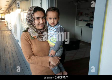 Austin, TX, USA. 19th. November 2021. Eine afghanische Familie posiert in ihrer neuen Wohnung in der Nähe der University of Texas in Austin. Drei Monate lang werden Flüchtlinge, die vor den Unruhen in Afghanistan fliehen, nach Texas umgesiedelt, wobei viele alleinstehende Männer, große Familien mit Kindern, unter Dutzenden von Wohnungen in Austin, Texas, settelten. Religiöse Gruppen haben sich verstärkt, um die Bemühungen um die Einrichtung von Häusern für Hunderte von Flüchtlingen zu koordinieren. (Bild: © Bob Daemmrich/ZUMA Press Wire) Stockfoto