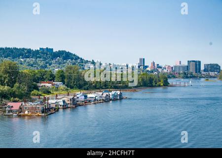 Ein Blick auf eine Hausbootgemeinschaft vor der Skyline von Portland, aufgenommen von der Sellwood-Brücke an einem schönen sonnigen Tag. Stockfoto