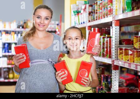 Mutter mit Teenager-Mädchen, die ihre Auswahl beim Essen demonstrierten Stockfoto