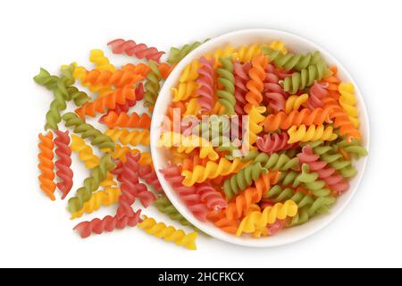 Rohe Fusilli farbige Pasta in Keramikschale isoliert auf weißem Hintergrund mit Clipping-Pfad und volle Schärfentiefe. Draufsicht. Flach liegend Stockfoto